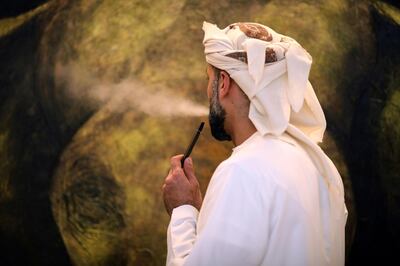 An Emirati man poses while smoking an e-cigarette at his home in Dubai, United Arab Emirates August 22, 2019. Picture taken August 22, 2019. REUTERS/Christopher Pike