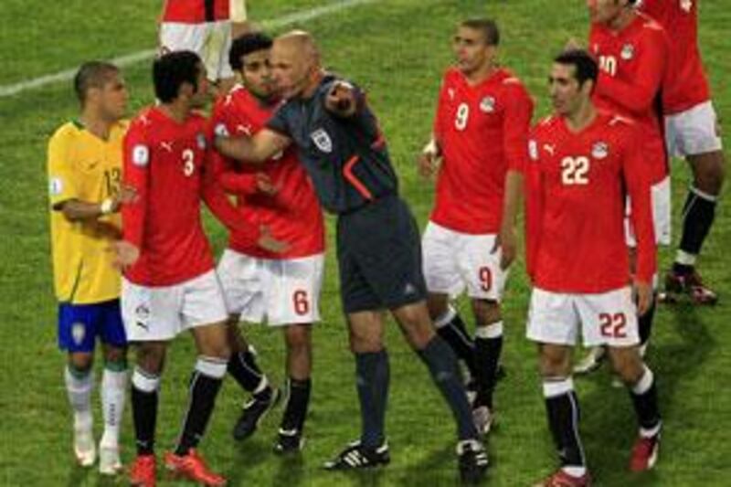 Howard Webb, centre, asks Egypt's Ahmed al Muhamadi, second from left, to leave the field after giving him a red card.