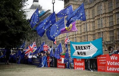 Leave and remain supporters wave flags and banners as they protest opposite Parliament Square in London, Tuesday, Sept. 3, 2019. Parliament was reconvening Tuesday for a pivotal day in British politics as lawmakers challenge British Prime Minister Boris Johnson's insistence that the U.K. will leave the European Union on Oct. 31, 2019 even without a deal. (AP Photo/Matt Dunham)