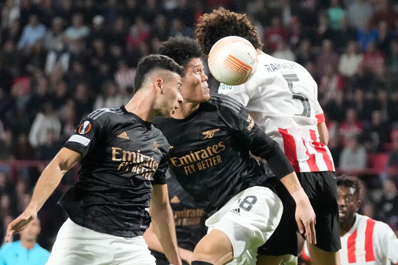 Arsenal's Takehiro Tomiyasu and Gabriel Martinelli jump for a header with PSV's Andre Ramalho. AP