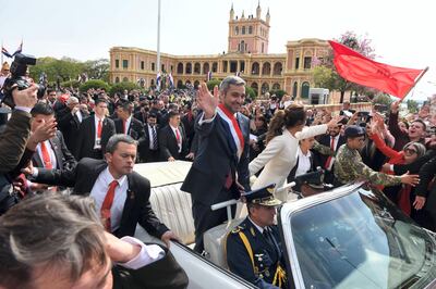 Paraguay's new President Mario Abdo Benitez and his wife Silvana Lopez head to the Cathedral on a 1967 Cadillac convertible after the swearing-in ceremony at the presidential palace in Asuncion, on August 15, 2018. / AFP PHOTO / Daniel DUARTE