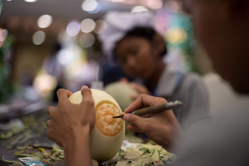 A Thai girl carves floral patterns into a melon during a fruit and vegetable carving competition in Bangkok. Robert Schmidt / AFP