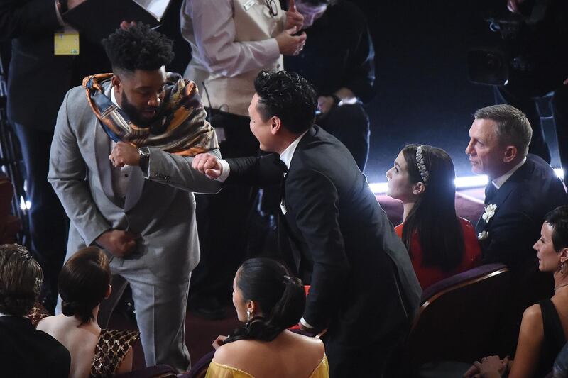Black Panther Ryan Coogler (L) checks in with Henry Golding (C) as actor Daniel Craig and Rachel Weisz (R) look on. Photo: AFP
