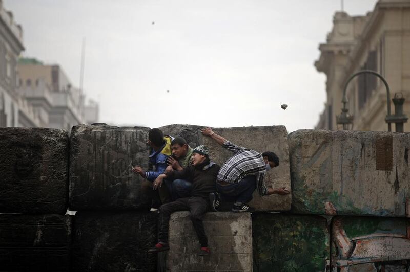 Protesters hide from security forces, unseen, near Tahrir Square, Cairo. Khalil Hamra / AP

