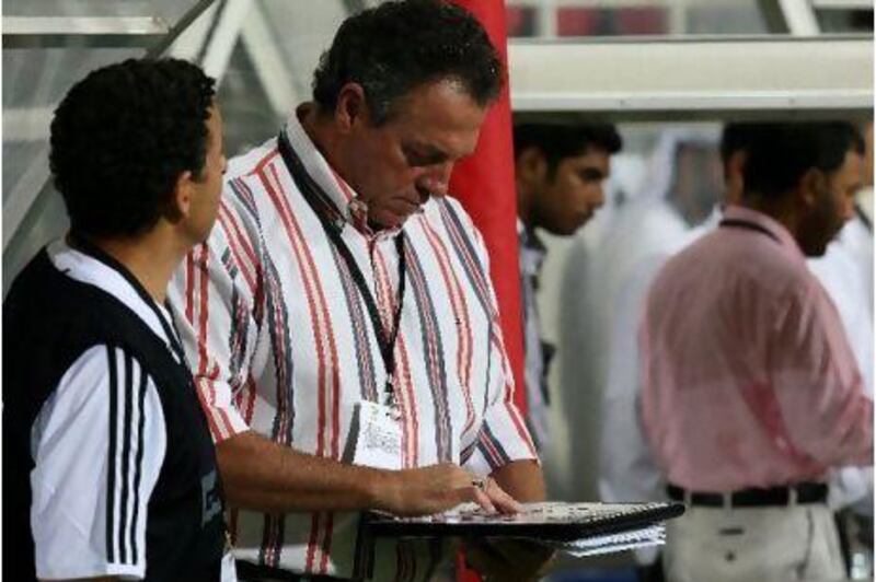 Abel Braga, coach of Al Jazira club, checks his squad list before the match against arch-rivals Al Wahda club.