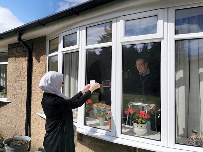 My daughter Sarah is showing her housebound grandfather the 12-week scan photograph of her first baby. She had the scan a few days earlier and drove to her grandparents’ house so she could stand outside and show it to them by JULIE AOULAD-ALI AND KAMAL RIYANI
