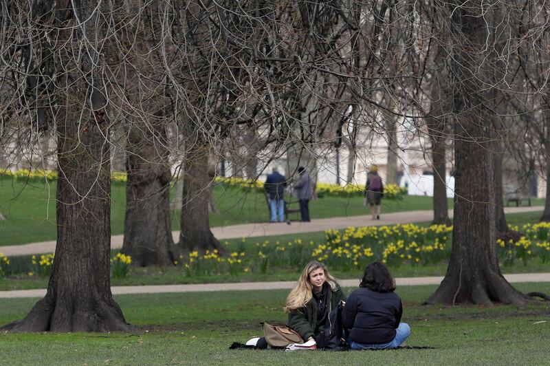 Two people sit on the grass in St James's Park in London.  As part of the governments plans to ease lockdown restrictions in England, as of Monday people can leave home for recreation outdoors such as a coffee or picnic with one person outside their household. AP Photo