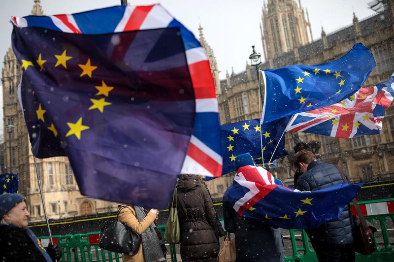 LONDON, ENGLAND - FEBRUARY 26: Anti-Brexit demonstrators protest with flags during a snow flurry outside the Houses of Parliament on February 26, 2018 in London, England. Labour Leader Jeremy Corbyn's Brexit speech today confirmed that a Labour Government would negotiate full tariff-free access to EU markets for UK business. (Photo by Jack Taylor/Getty Images)