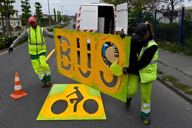 City workers use stencils to mark a bicycle and bus traffic line on a road in Saint-Malo, Brittany, France. AFP