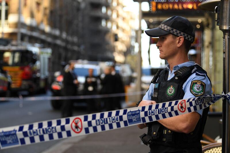 A policeman stands by a roped off crime scene after a man stabbed a woman and attempted to stab others in central Sydney.  AFP