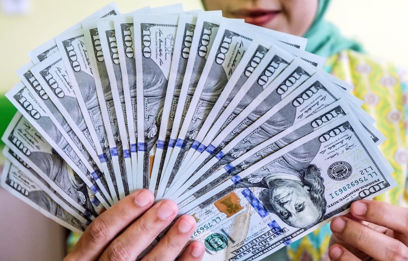 epa07034059 An Indonesian exchange employee holds US dollar banknotes at a money exchange point in Medan, North Sumatra, Indonesia, 20 September 2018. The Indonesian rupiah recorded at 14,845 per US dollar on 20 September.  EPA/DEDI SINUHAJI
