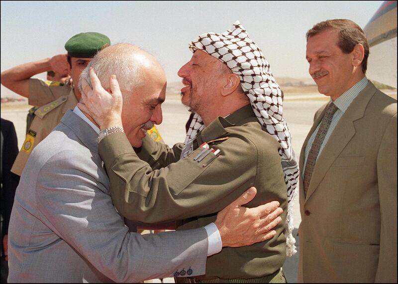 Yasser Arafat (c), President of Palestine Liberation Organisation (PLO) shown in picture dated 20 September 1993 in Amman, kissing the head of King Hussein of Jordan as Yasser Abed Rabbo (r), the chief of the PLO information departement looks on, during Arafat's arrival at Marka airport. (Photo by RABIH MOGHRABI / AFP FILES / AFP)