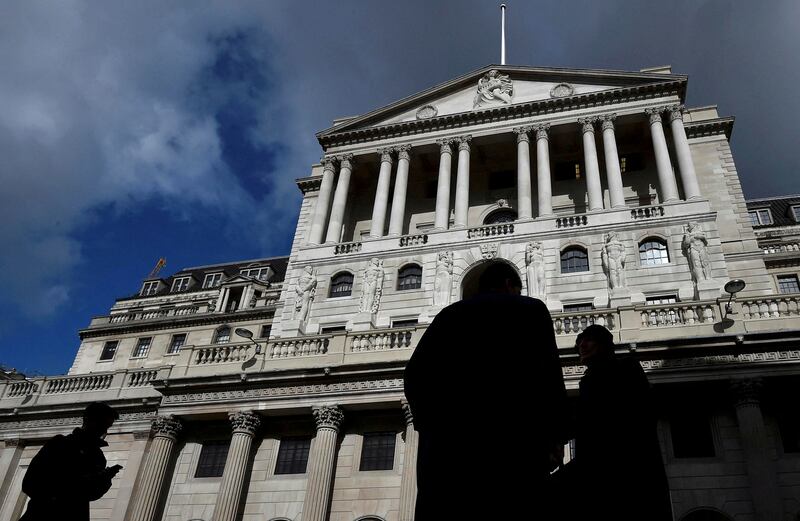 Workers walk past the Bank of England in the City of London. Reuters