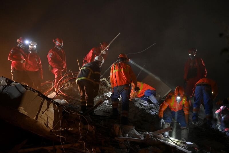 Rescuers wear headlamps as they search for survivors in a collapsed building after a powerful earthquake struck Turkey's western coast and parts of Greece, in Izmir.  AFP