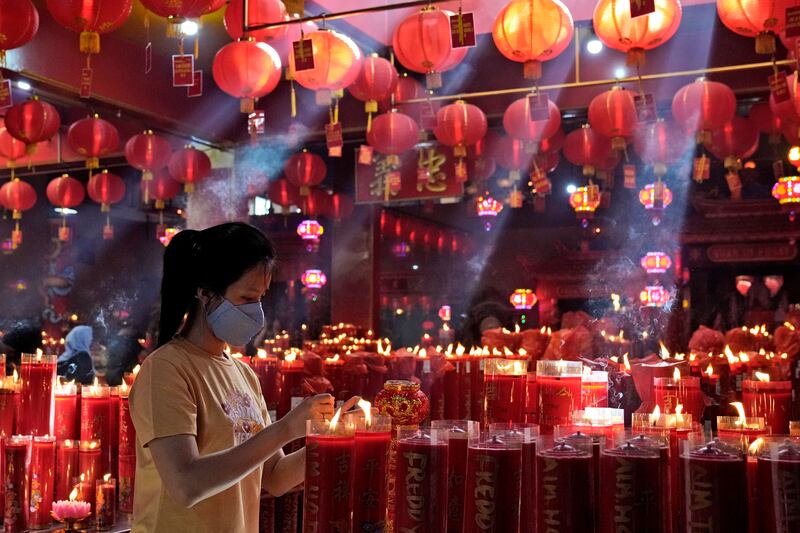 A woman lights a candle during Lunar New Year celebrations at the Hok Lay Kiong temple in Bekasi, Indonesia. AP Photo