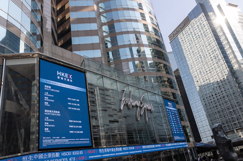 Electronic billboards display stock transactions on Exchange Square, the building housing the bourse, in Hong Kong, China.  The Hang Seng Index fell to the lowest level in 14 months amid growing concerns the Omicron variant of the coronavirus will derail global economic recovery. EPA