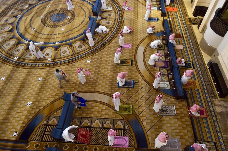 Saudi Muslim worshippers observe a safe distance as they perform noon prayer at Al Rajhi mosque in the capital Riyadh. AFP