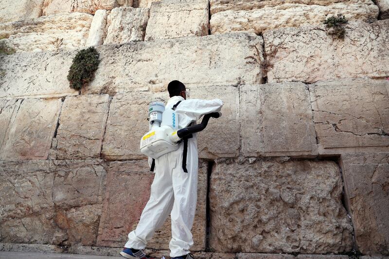 A labourer disinfects and clears out notes left by worshippers in the cracks between the stones of the Western Wall, Judaism's holiest prayer site, ahead of the Jewish New Year, amid the coronavirus disease (COVID-19) crisis, in Jerusalem. REUTERS