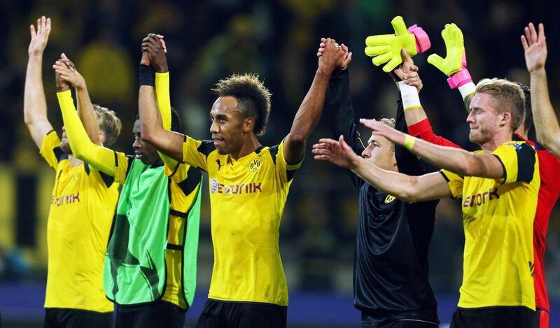 Borussia Dortmund players Pierre-Emerick Aubameyang, centre, and Andre Schurrle, right, celebrate with fans after the Champions League Group F match. Ina Fassbender / EPA