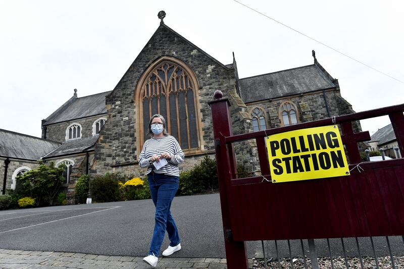 A woman walks outside a polling station in St Peter's Church of Ireland on the day of the Northern Ireland Assembly elections, in Belfast. Reuters