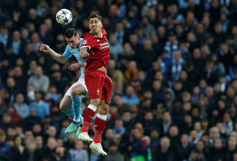 Liverpool's Roberto Firmino in action with Manchester City's Aymeric Laporte. Andrew Yates / Reuters