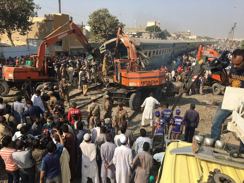 Rescuers workers use heavy machinery to move a carriage after two trains collided in Karachi, Pakistan, on November 3, 2016. Akhtar Soomro / Reuters