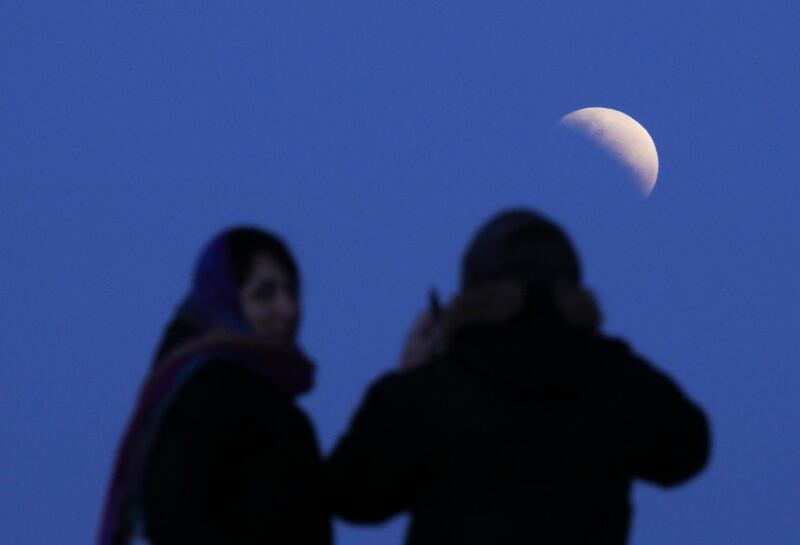 A couple watches the eclipse in Buenos Aires, Argentina. AP Photo/Natacha Pisarenko