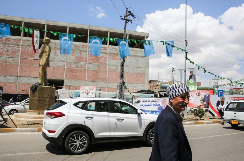 A picture taken on April 30, 2018 shows the flags of the Iraqi Turkmen (white crescent and stars on a blue background) hanging next to other banners and flags for candidates and lists in the upcoming May 12 parliamentary polls, along a street in the oil-rich and multi-ethnic northern city of Kirkuk.
The past seven months have seen a dramatic turn of events in Kirkuk, the "Jerusalem of Kurdistan", where hopes of independence for Iraqi Kurdistan were dashed after Baghdad retaliated against a referendum held in September. / AFP PHOTO / SABAH ARAR