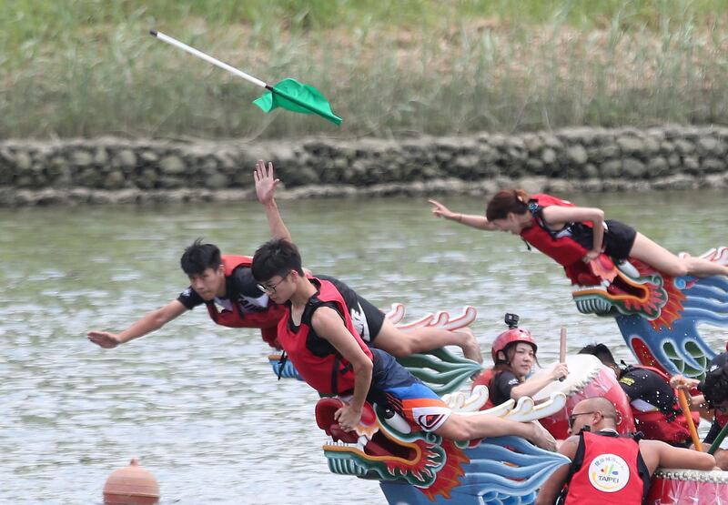 A boat leader tries to grab the finish line flag during the traditional Chinese dragon boat race in Taipei, Taiwan. AP Photo