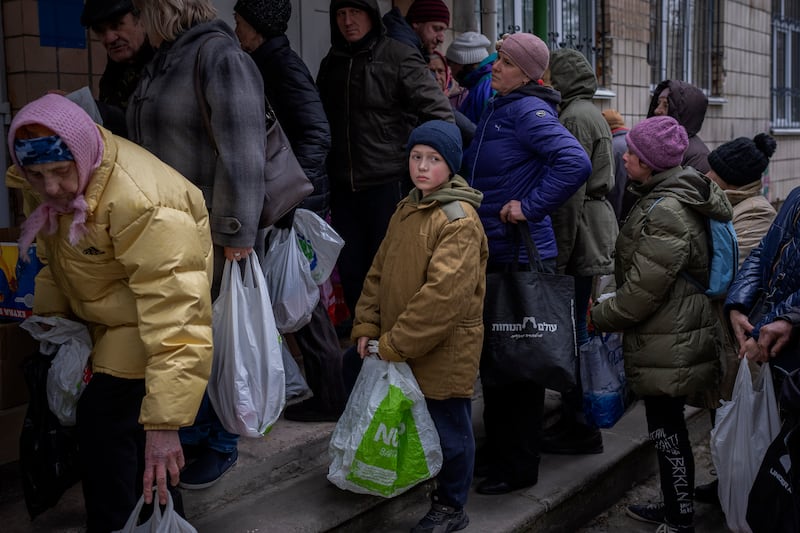 Sergei, 11, waits his turn to receive donated food during an aid humanitarian distribution in Bucha. AP