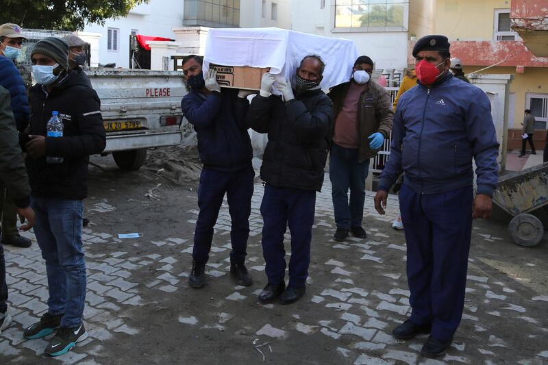 Health workers carry the coffin of a victim killed in a stampede at the Mata Vaishno Devi shrine, at a hospital in Katra, India. The stampede at the Hindu shrine in Indian-controlled Kashmir killed at least 12 people and injured 13 others on New Year’s Day, officials said.  AP Photo