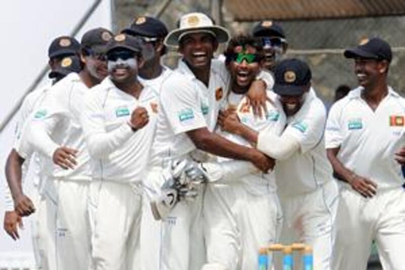 Sri Lankan cricketers celebrate the dismissal of Pakistan's Misbah-ul-Haq as they win the first Test of a three-match series.