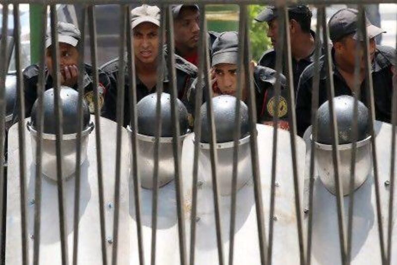 Egyptian security forces stand behind the gates of Cairo’s parliament building as they await protesters.