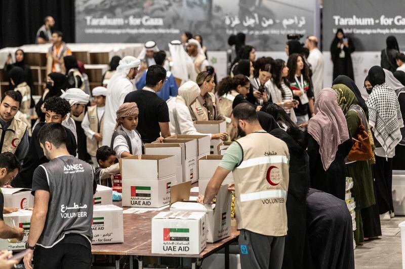 Volunteers at the Abu Dhabi National Exhibition Centre pack aid boxes for Palestinian people in Gaza. Photos: Antonie Robertson  /The National