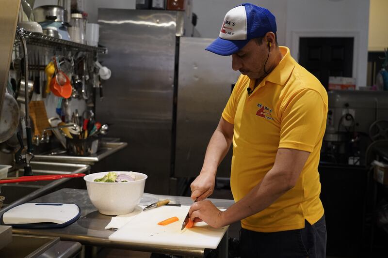 Youssef Ibrahim chops a carrot in his restaurant's kitchen. Willy Lowry / The National.