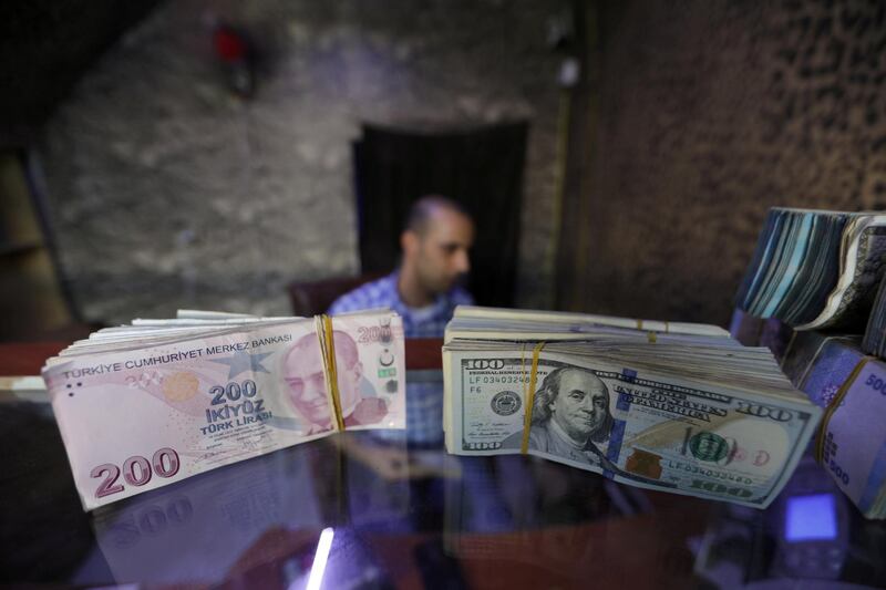 FILE PHOTO: Banknotes of U.S. dollars and Turkish lira are seen in a currency exchange shop in Azaz, Syria, August 18, 2018. REUTERS/Khalil Ashawi/File Photo