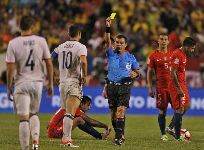 El Salvadorean referee Joel Aguilar (C) shows the yellow card to Colombia's James Rodriguez (2-L) during a Copa America Centenario semifinal football match against Chile in Chicago, Illinois, United States, on June 22, 2016. / AFP / Tasos Katopodis