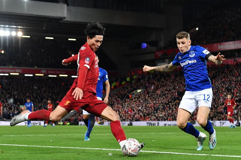 Liverpool's Japanese midfielder Takumi Minamino with Everton's Lucas Digne at Anfield. AFP