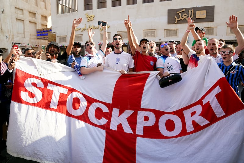 England fans with a Stockport County flag, in the Souq area of Doha. PA