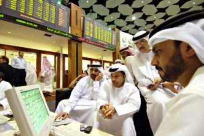 Men look over a quote screen on the floor of the Dubai Financial Market, in the Dubai World Trade Centre in Dubai, United Arab Emirates Sunday, January 15, 2006.  Photographer: Charles Crowell/Bloomberg News