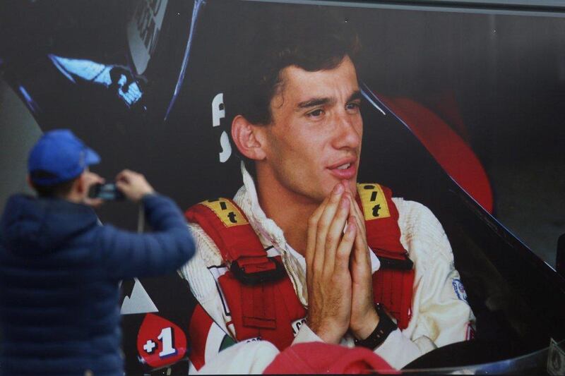 A man takes a photo of a poster depicting Ayrton Senna at the Imola race track on Wednesday. Giorgio Benvenuti / EPA / April 30, 2014