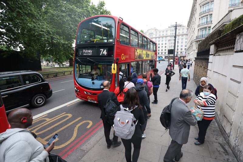 Members of the public queue for a bus near Marble Arch in London. PA