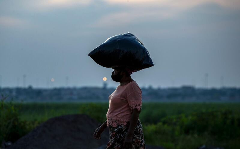 A woman walka back home from work in Spruitview near Johannesburg, South Africa. AP Photo