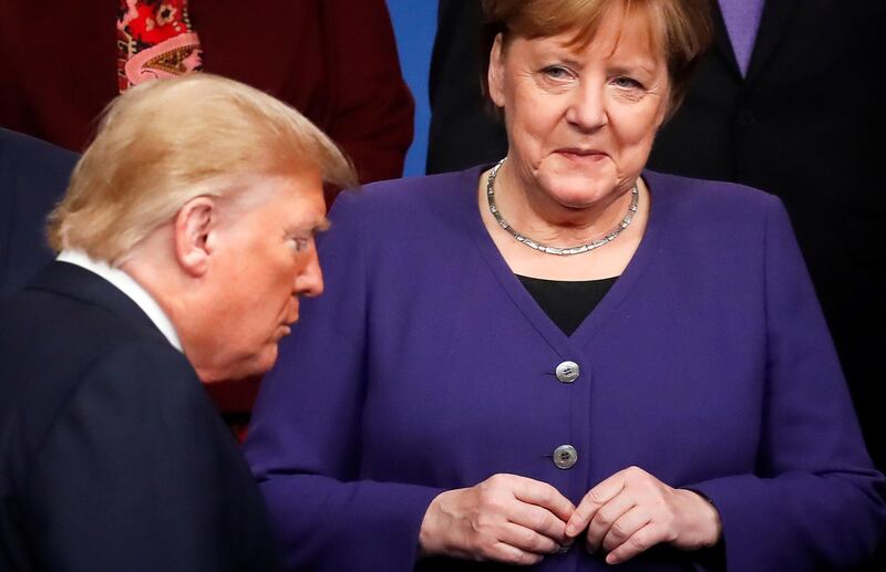 (FILES) In this file photo taken on December 04, 2019 Germany's Chancellor Angela Merkel (R) looks at US President Donald Trump (R) walking past her during a family photo as part of the NATO summit at the Grove hotel in Watford, northeast of London on December 4, 2019. German Chancellor Angela Merkel will not attend an in-person summit of G7 leaders that US President Donald Trump has suggested he will host despite concerns over the coronavirus pandemic, according with German government spokesman. / AFP / POOL / CHRISTIAN HARTMANN
