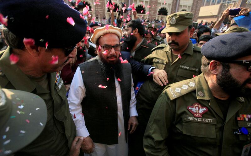 FILE PHOTO: Hafiz Saeed is showered with flower petals as he walks to court before a Pakistani court ordered his release from house arrest in Lahore, Pakistan November 22, 2017. REUTERS/Mohsin Raza/File Photo