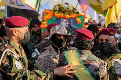 PMF fighters in balaclavas at the funeral on Thursday. AP Photo