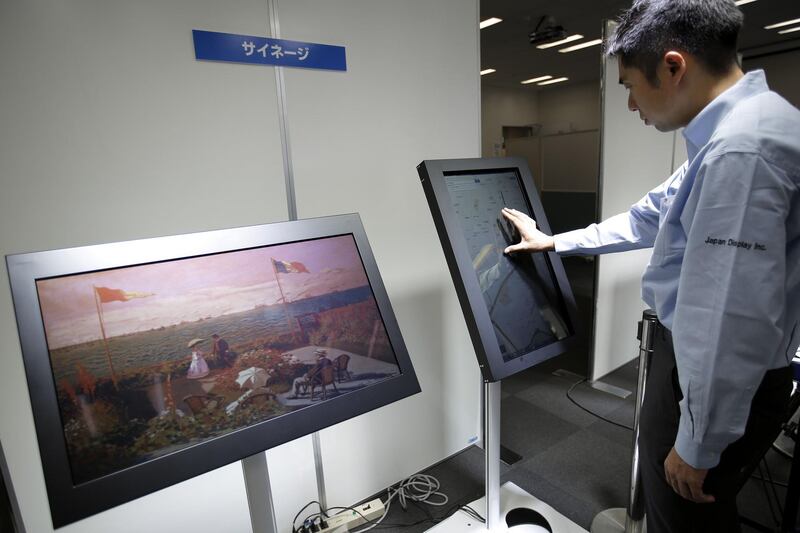 An attendant demonstrates the touch panel function on a reflective color liquid crystal display (LCD), developed by Japan Display Inc., presented as a guide map at a media event in Tokyo, Japan, on Monday, June 15, 2015. Japan Display is a supplier of mobile-device screens to Apple Inc. Photographer: Kiyoshi Ota/Bloomberg