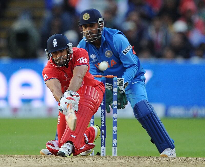 England's Ravi Bopara (L) hits a six as Indian captain Mahendra Sing Dhoni looks on during the 2013 ICC Champions Trophy Final cricket match between England and India at Edgbaston in Birmingham, central England on 23, June 2013.  India scored 129 runs for the loss of seven wickets after the rain delayed match was reduced reduced to the bare minimum of 20 overs per side required to produced a result.   AFP PHOTO/ANDREW YATES
 RESTRICTED TO EDITORIAL USE
 *** Local Caption ***  409115-01-08.jpg