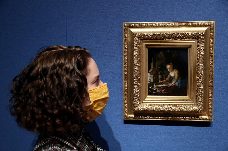 A lady looks at the Gerrit Dou painting "A Girl Chopping Onions". Getty Images