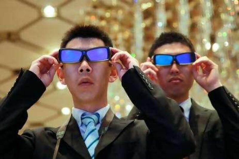 Visitors wearing 3-D glasses watch 3-D images on Sharp Corp.'s four-primary-color 3-D liquid-crystal display (LCD) panels at a media preview in Tokyo, Japan, on Monday, April 12, 2010. Sharp Corp. said it plans to start selling 3-D televisions from this summer and will offer the products in Japan, the U.S., Europe and China as it seeks to boost group sales from the new market. Sharp Corp. unveiled it has developed the world's first four-primary-color 3-D liquid-crystal display (LCD) panels that can show 3-D images. Photographer: Kimimasa Mayama/Bloomberg